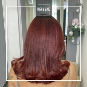 Mittellanges, welliges Haar in einem satten Rotton, gefärbt mit ammoniakfreier iNOA Haarfarbe beim Friseur Susan Matz - Coiffeur in Nürnberg.