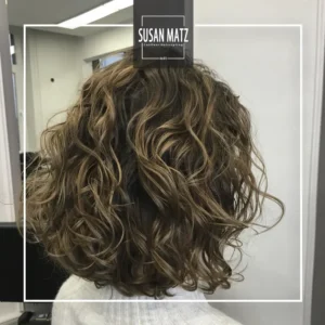 Naturlocken-Haarschnitt | Perfekt gestyltes Curly Hair in Nürnberg Rückenansicht einer Kundin mit einem voluminösen, schulterlangen Lockenhaarschnitt (Curly Hair) und definierten Naturlocken. Styling beim Friseur Susan Matz - Coiffeur in Nürnberg.